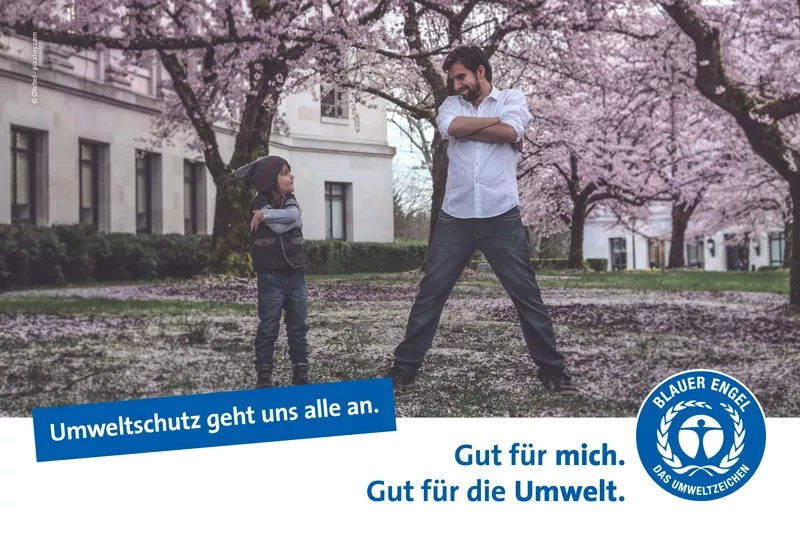Kind und Mann unter japanischen Kirschblüten. Slogan: Umweltschutz geht uns alle an. 